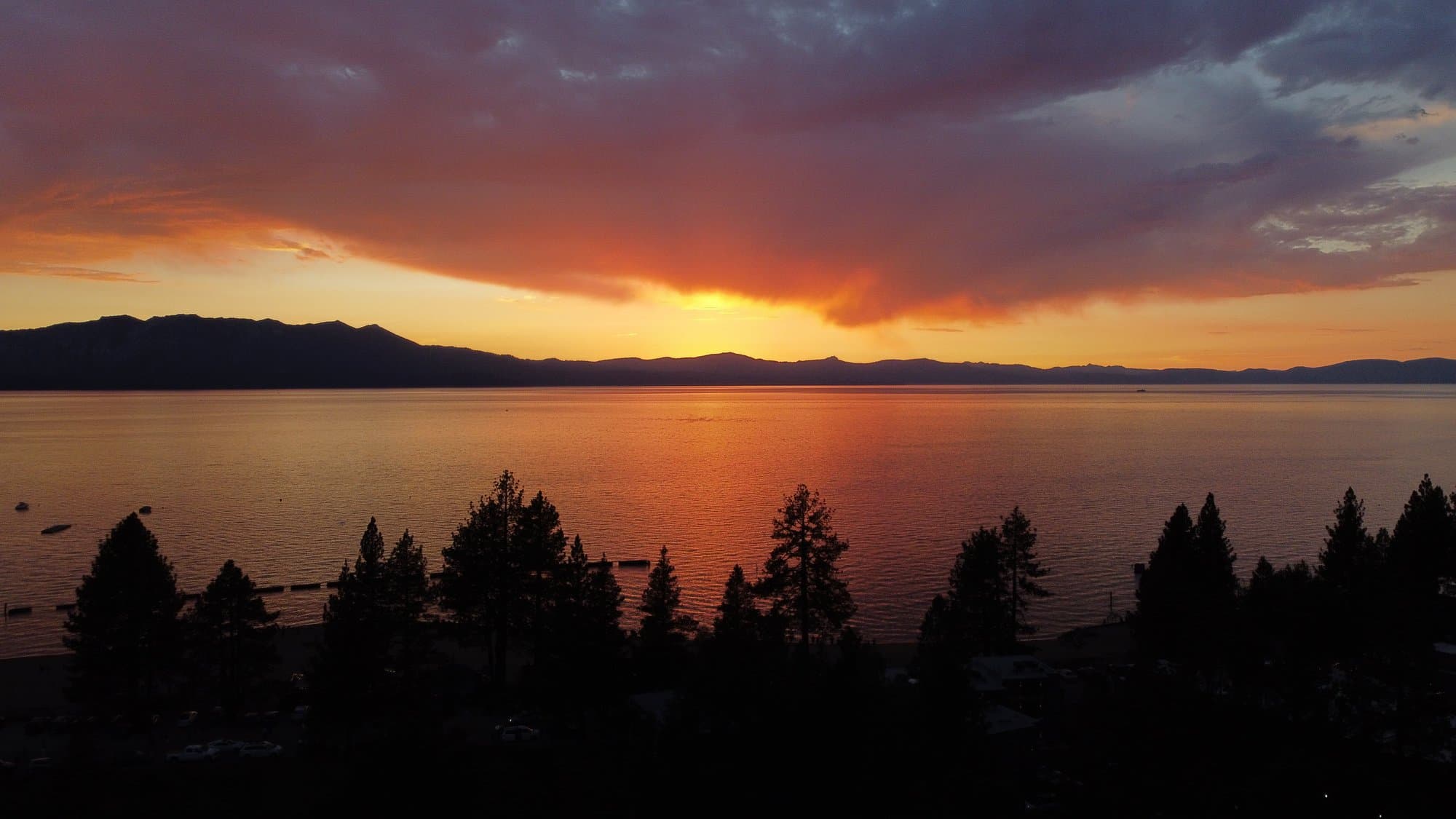 Lake Tahoe at sunset, mountains silhouetted under an orange-and-violet sky