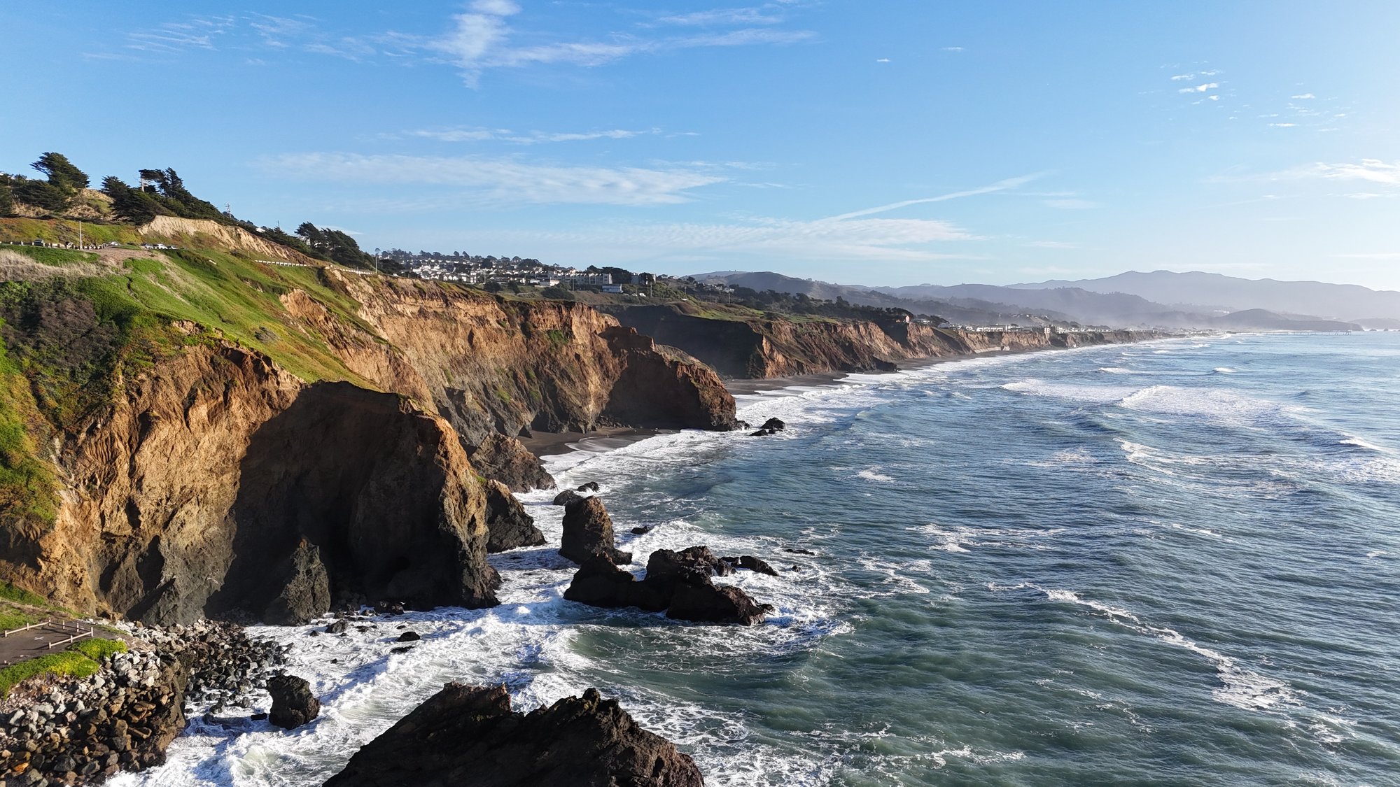 Pacifica coastal cliffs at golden hour, shot from the air